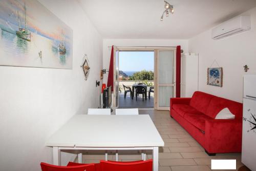 ein Wohnzimmer mit einem roten Sofa und einem Tisch in der Unterkunft Vacanze da Favola in Castelsardo