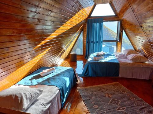 pokój z 2 łóżkami w drewnianym pokoju w obiekcie Cottage Hillside in Juta w mieście Juta