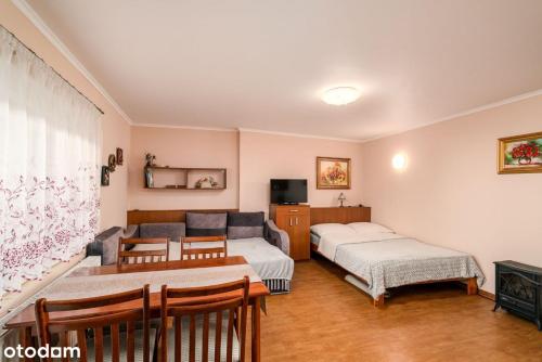 a living room with two beds and a couch at Apartament Rubinowy in Polanica-Zdrój