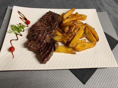 a steak and french fries on a white plate at La Roselière in Saint-Quentin-Fallavier