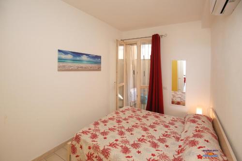Schlafzimmer mit einem Bett und einem Fenster in der Unterkunft Vacanze da Favola in Castelsardo