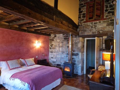 a bedroom with a bed and a wood stove at La Casona de Barrio in Barrio