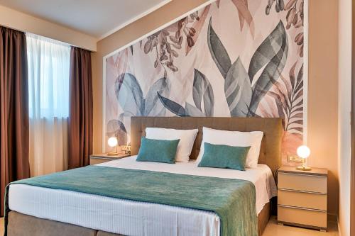 ein Schlafzimmer mit einem großen Bett und einem Blumenbild an der Wand in der Unterkunft Villa Astrid***** in Labin