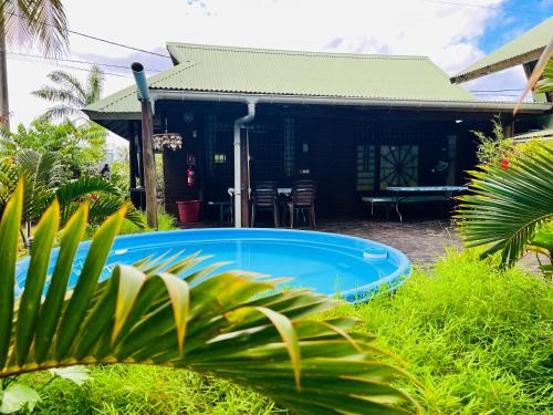 a swimming pool in front of a house at My Island Home in Fare