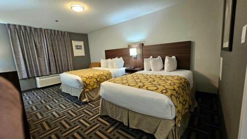 a hotel room with two beds and a window at Baymont by Wyndham Chicago/Calumet City in Calumet City