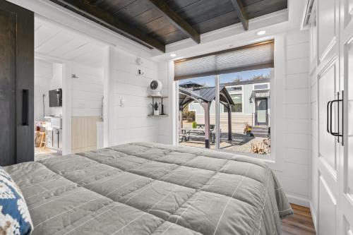 a bedroom with a large bed and a large window at Red Door Tiny Home Lewis Ranch in Lindsay