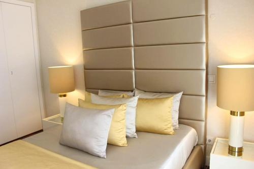 - une chambre avec un lit avec des oreillers et 2 lampes dans l'établissement 2 bedrooms apartement with shared pool and wifi at Lisbon, à Lisbonne