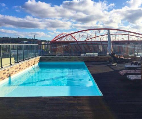 - une piscine au-dessus d'un bâtiment avec un pont dans l'établissement 2 bedrooms apartement with shared pool and wifi at Lisbon, à Lisbonne