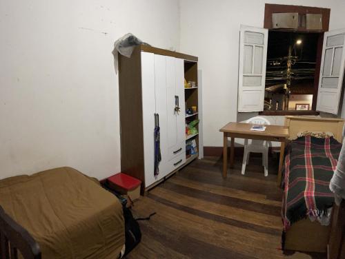 オウロ・プレットにあるQuarto inteiro, próx ao Centro - República Saideiraのベッド、デスク、キャビネットが備わる客室です。