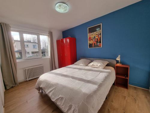 um quarto com uma cama grande e uma parede azul em La Bulle em Liévin
