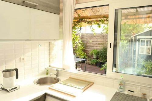 eine Küche mit einem Waschbecken und einem Fenster in der Unterkunft Appartement de 2 chambres avec terrasse et wifi a Bagnolet in Bagnolet