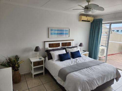 um quarto com uma cama grande e almofadas azuis em Ithaca 9 Margate em Margate