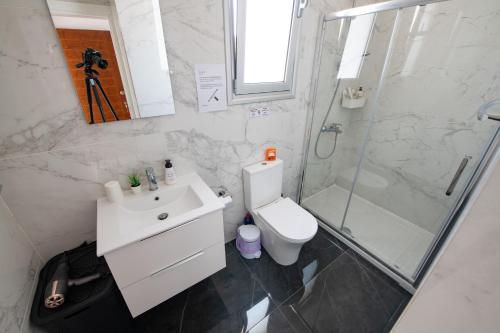 a bathroom with a toilet and a shower and a sink at Dream- Downtown-Studios in Paphos City
