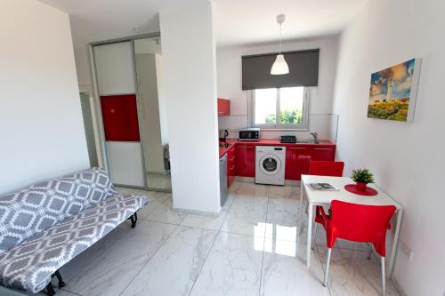 a bedroom with a bed and a table and a kitchen at Dream- Downtown-Studios in Paphos