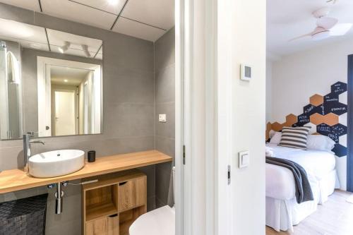 a bathroom with a sink and a mirror and a bed at Genoveses Suites, 3 Hab, garaje, piscina, solárium y WiFi in San José