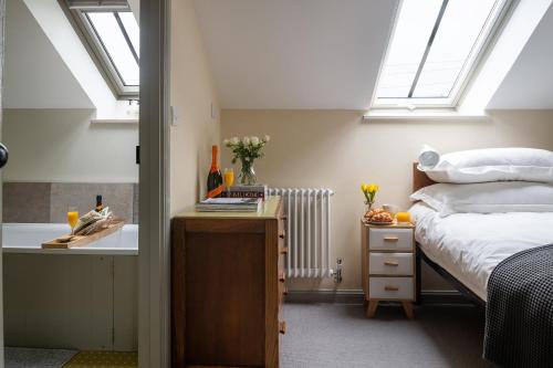 a bedroom with a bed and a sink with skylights at The Tackhouse in Greenlaw