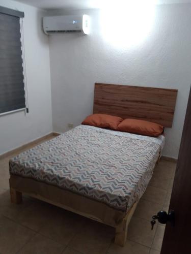 a bedroom with a bed with a wooden head board at Depa Eco en planta baja, a 5 minutos del malecon y zona dorada in Mazatlán