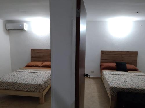 two beds in a small room with at Depa Eco en planta baja, a 5 minutos del malecon y zona dorada in Mazatlán