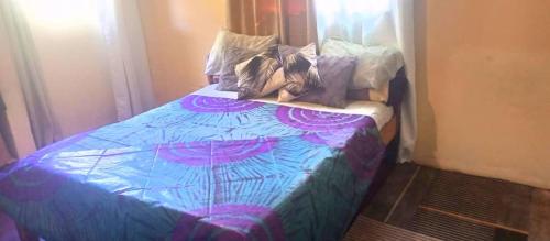 Una cama con un edredón azul con zapatos. en DNB 311, en Livingstone