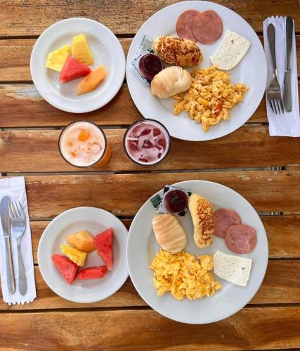 four white plates of food on a wooden table at Hotel La Fragata in Coveñas