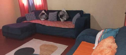 sala de estar con sofá azul y almohadas en DNB 311 en Livingstone