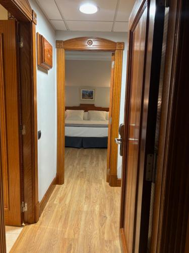 a hallway with a bedroom with a bed and a door at Gran Hotel Liber & Spa Playa Golf in Noja