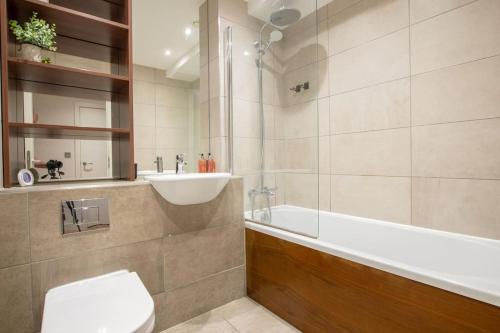 een badkamer met een bad, een toilet en een wastafel bij Luxury City Centre Apartment (Weekly Booking) in Hull