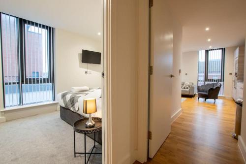 una camera con letto e tavolo con lampada di Luxury City Centre Apartment (Weekly Booking) a Hull