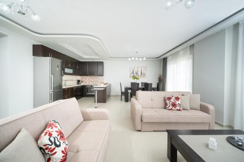 a living room with two couches and a kitchen at Tarsa's House by the Sea in Skala Marion