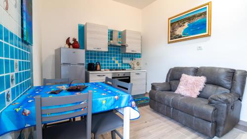 a living room with a table and a couch at Appartamento il Maestrale Casa Vacanza in Càbras