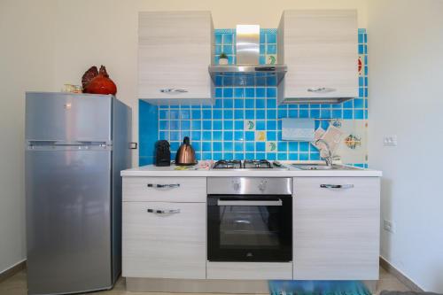 a kitchen with a stove and a refrigerator at Appartamento il Maestrale Casa Vacanza in Càbras