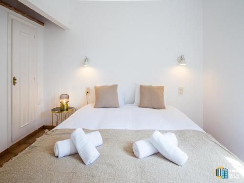 um quarto com uma grande cama branca e 2 almofadas em Villa LA KAZ em Castillo de Aro