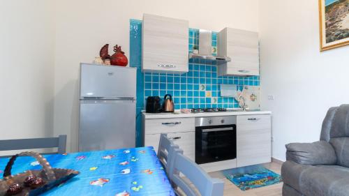 a kitchen with a refrigerator and a table in a room at Appartamento il Maestrale Casa Vacanza in Càbras
