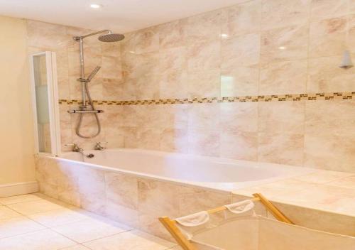 y baño grande con bañera y ducha. en Perfect Cotswold Home with vast stunning Ground's, en Painswick