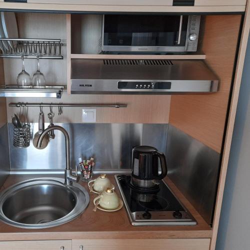 a small kitchen with a sink and a microwave at Cabo Verde in Agia Triada