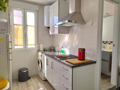 a white kitchen with a sink and a stove at Madrid Centro in Madrid