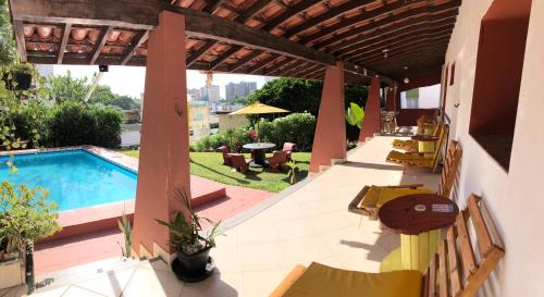 un patio con piscina, mesa y sillas en Point do Rio Vermelho, en Salvador