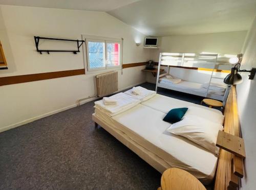 a bedroom with two bunk beds and a window at HOSTEL Les Bois Verts - Les Herbiers in Les Herbiers
