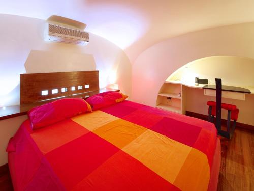 羅馬的住宿－鬥獸場甜蜜之家公寓，一间卧室,卧室里配有一张色彩缤纷的床