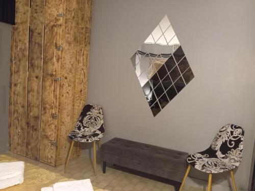 a room with two chairs and a mirror on the wall at Chez Ana à Morez in Morbier
