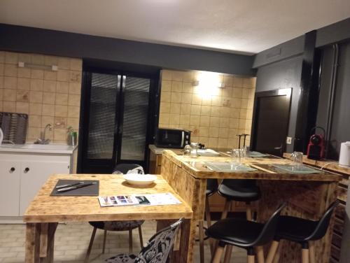 Chez Ana à Morez في موربييه: مطبخ مع طاولات وكراسي خشبية في الغرفة