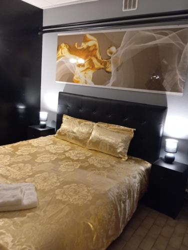 a bedroom with a bed with a painting above it at Chez Ana à Morez in Morbier