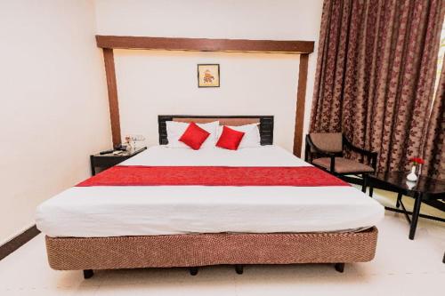 a bedroom with a large bed with red pillows at Garden Hotel Panvel in Navi Mumbai