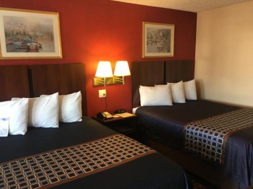 two beds in a hotel room with red walls at Americas Best Value Inn-Near NRG Park/Medical Center in Houston