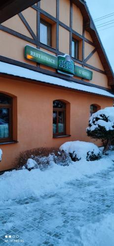 a building with snow on the ground in front of it at Penzion U Kata in Bruntál