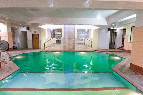 a large swimming pool in a large building at Garden Hotel Panvel in Navi Mumbai