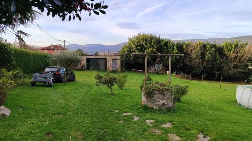 un patio con un camión aparcado en el césped en A Leiriña - Casa rural para desconexión en La Cañiza