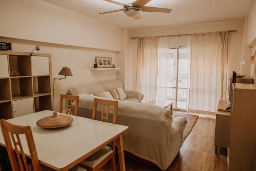 sala de estar con mesa y sofá en Apartamento pobla farnals playa, en Las Canteras