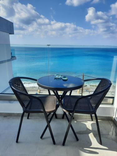a table and chairs on a balcony with a view of the ocean at Lilian's Seaview-Barstreet-Youth Studios in Rhodes Town