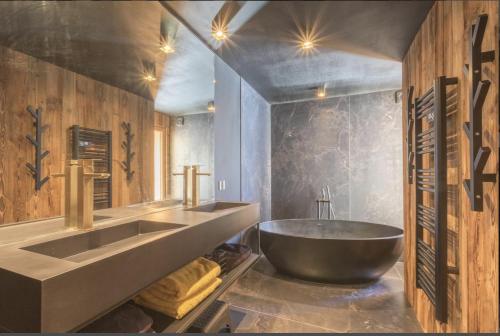 La salle de bains est pourvue d'un grand lavabo et d'une baignoire. dans l'établissement Luxury resort 5* Serrechevalier, au Monêtier-les-Bains